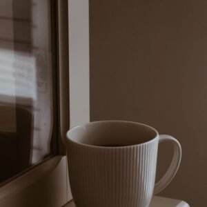 Warm coffee mug on window sill, creating a serene morning vibe.
