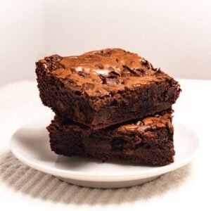 Rich and fudgy brownies stacked on a plate, perfect for dessert lovers.