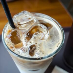 Close-up of a delicious iced milk tea with visible ice cubes and a straw.